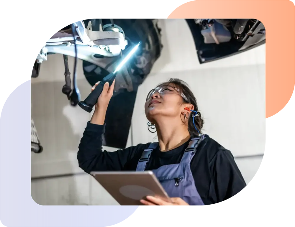 a female vehicle engineer checking a vehicle in the workshop as part of dealership operations