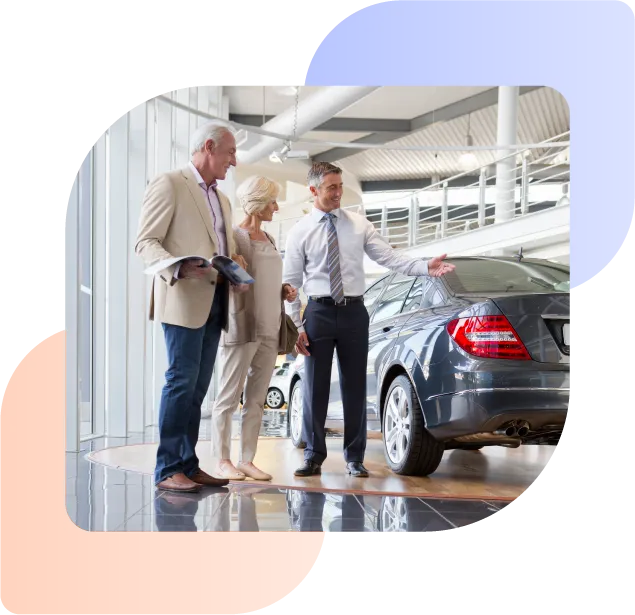 car dealer helping two customers buy a car