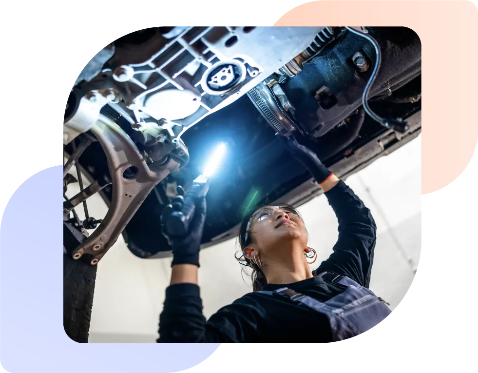 a female vehicle engineer checking a vehicle in the workshop as part of dealership operations